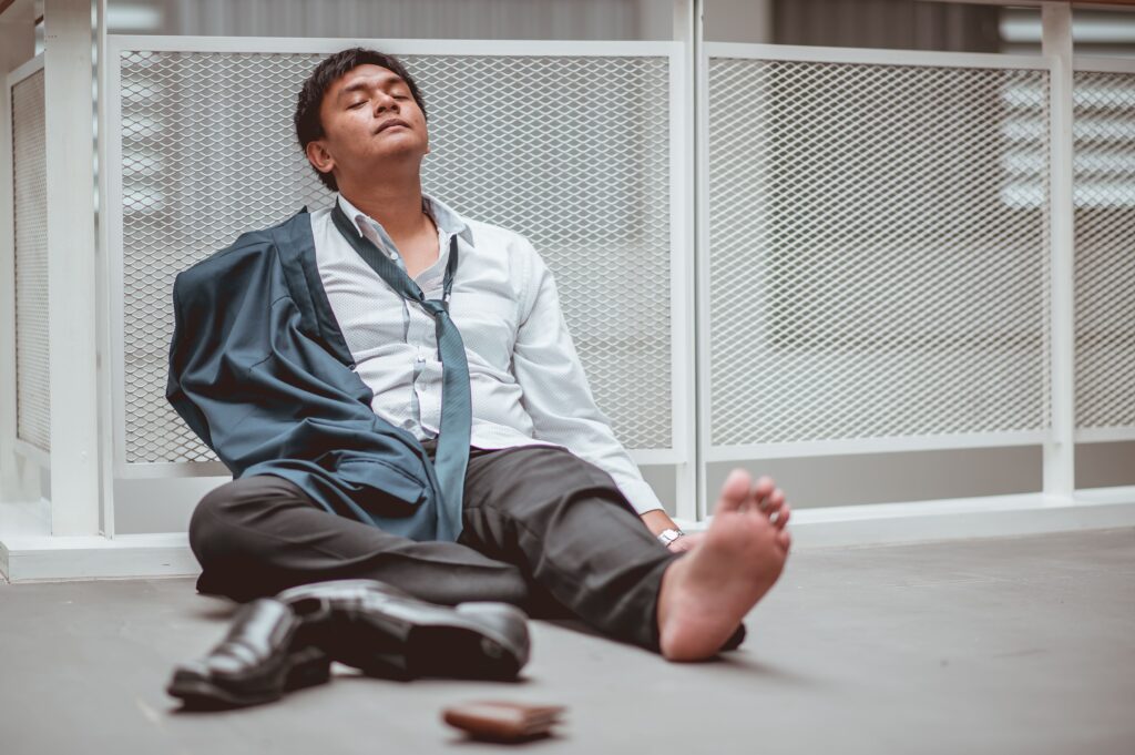 疲れて座っている男性の画像