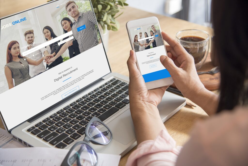 パソコンとスマートフォンをみている女性の画像