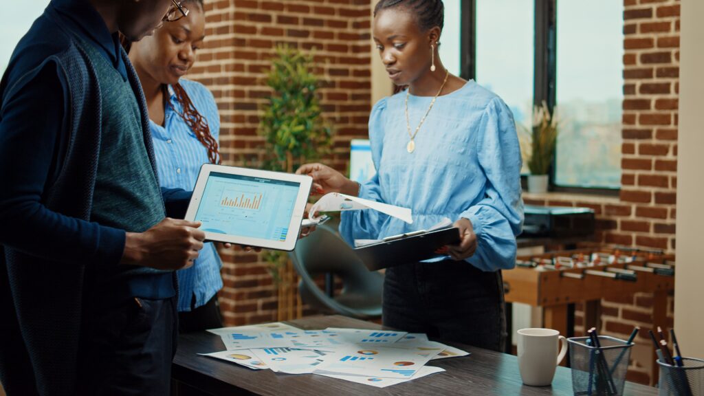 資料を囲んでミーティングをしている男性と女性の画像