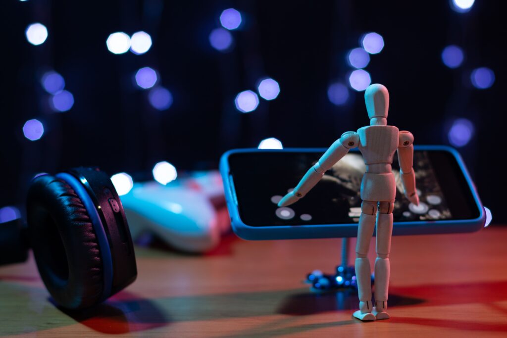 小さい人型の人形がスマートフォンに向けて手を広げている様子が描かれた画像